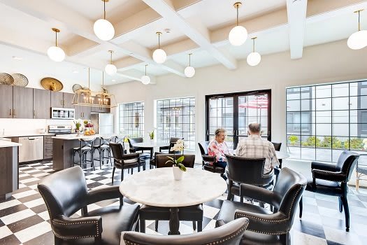 A cozy cafe interior with people socializing at tables under soft lighting.