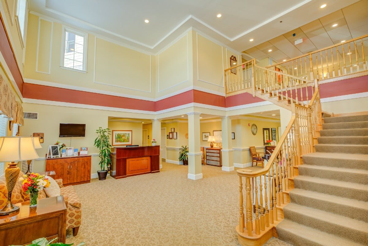 A spacious lobby with a grand staircase and reception desk.