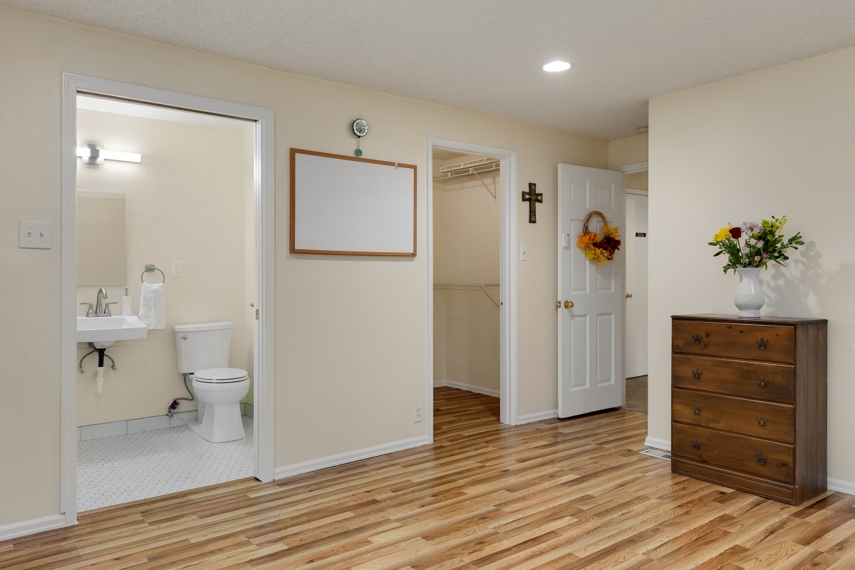 A cozy home interior with a wooden floor, visible bathroom, and decorative elements.