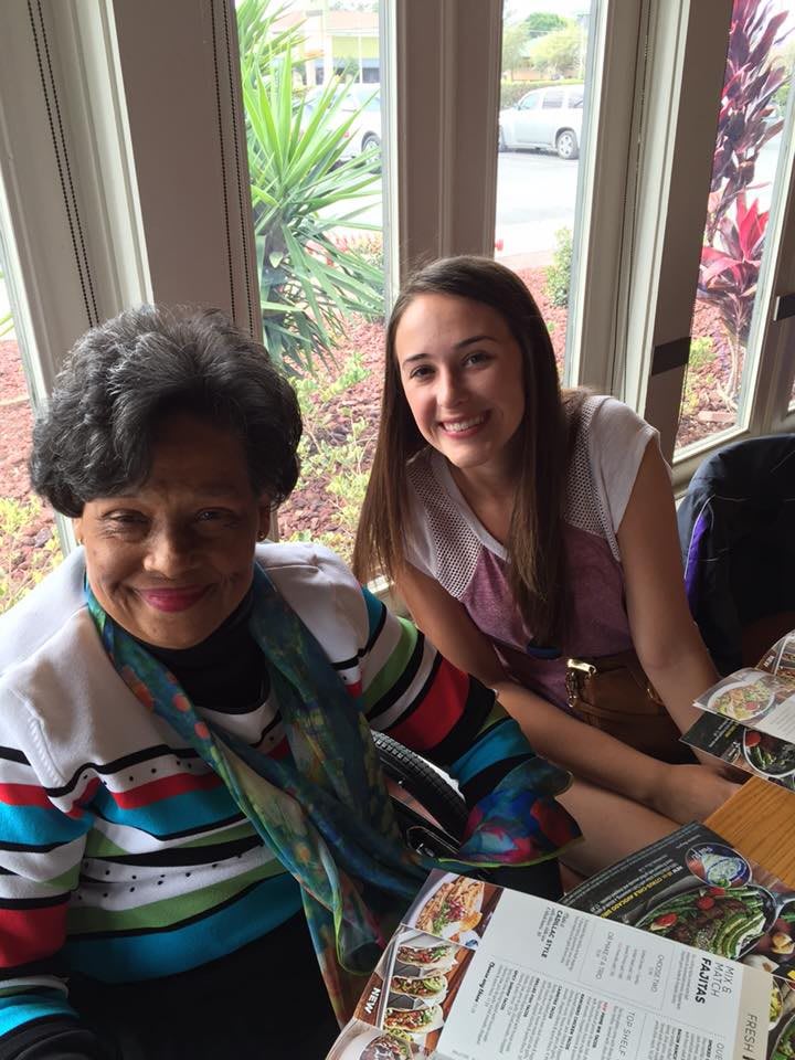 Two people smiling at a table in a restaurant.