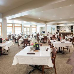 An empty restaurant dining area set up with neatly arranged tables and chairs.