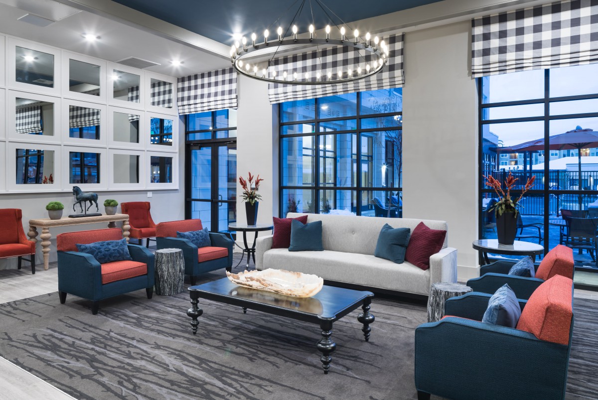 A modern living room with stylish furniture and a large chandelier.