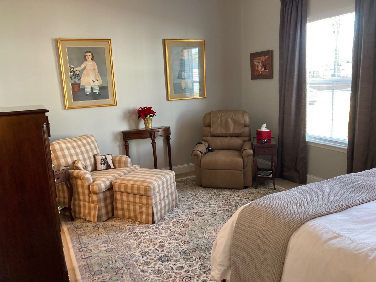 A cozy bedroom with an armchair, recliner, and decorative elements.