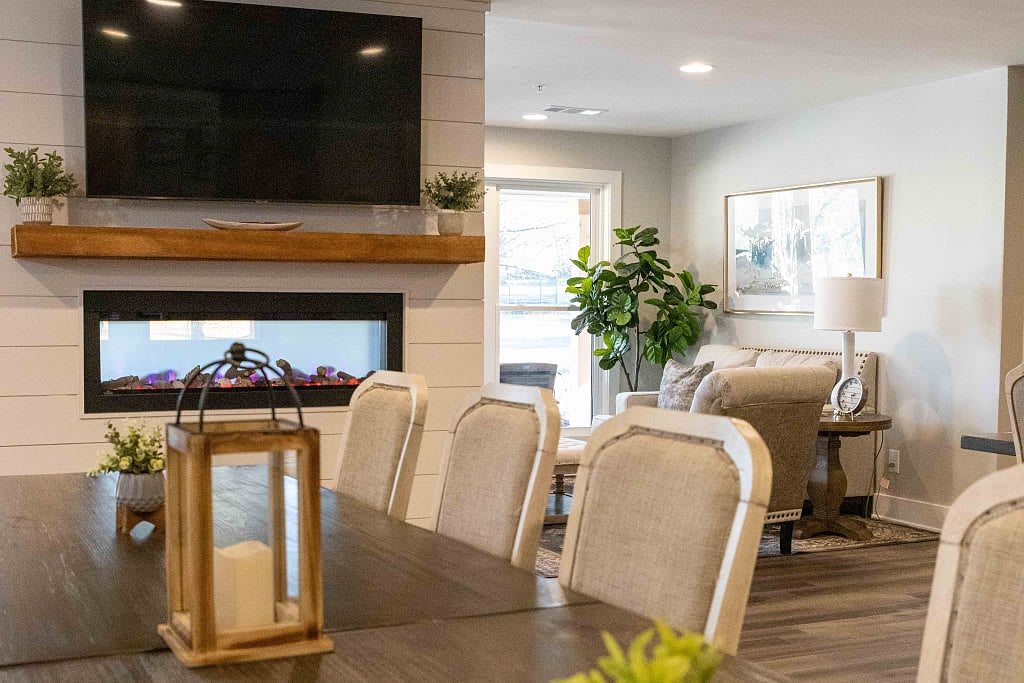 A cozy living room with a dining area, featuring a fireplace and modern furnishings.