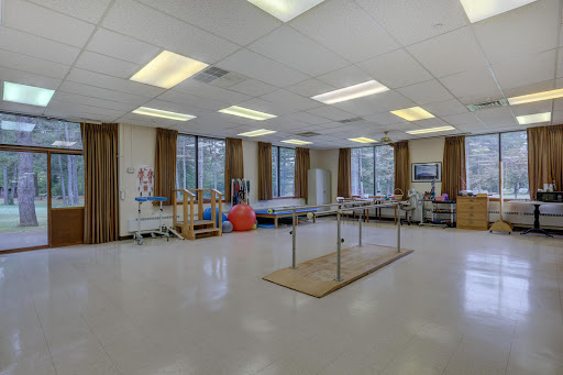 A spacious and well-lit physical therapy room equipped for rehabilitation exercises.