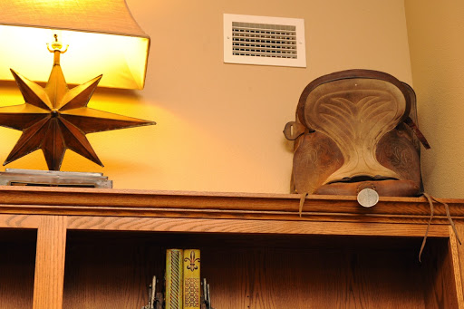 A cozy shelf showcasing a lamp, a decorative star, a wooden bowl, and some books.