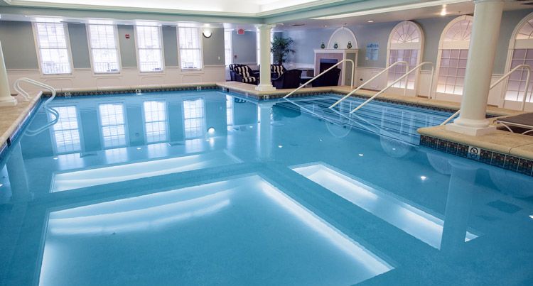 A spacious and inviting indoor swimming pool with bright lighting and modern design.