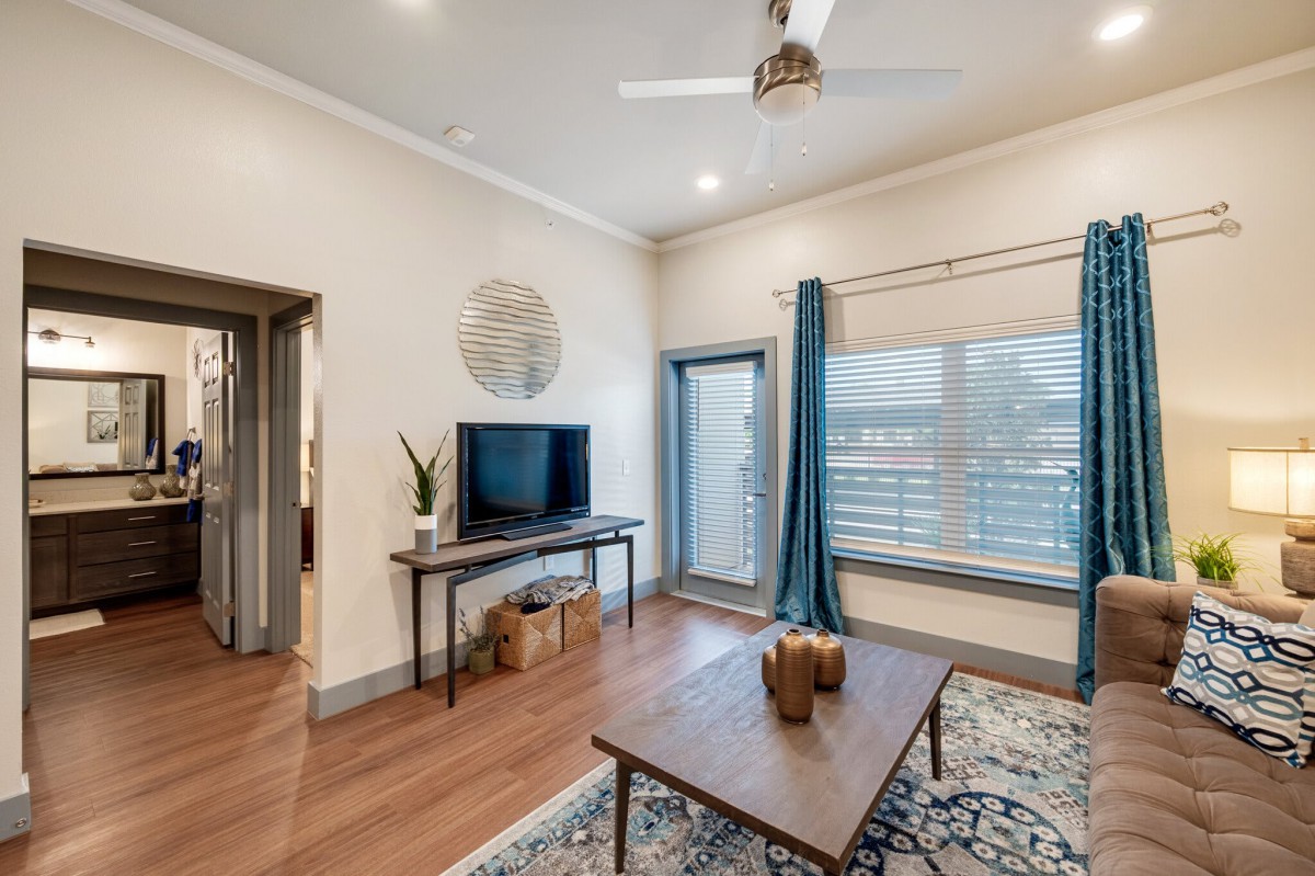 A modern living room with a stylish design, featuring a television, coffee table, and decorative elements.