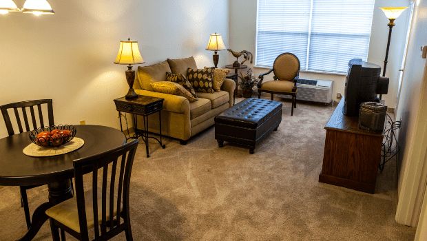 A cozy living room with a sofa, coffee table, and warm lighting from table lamps.