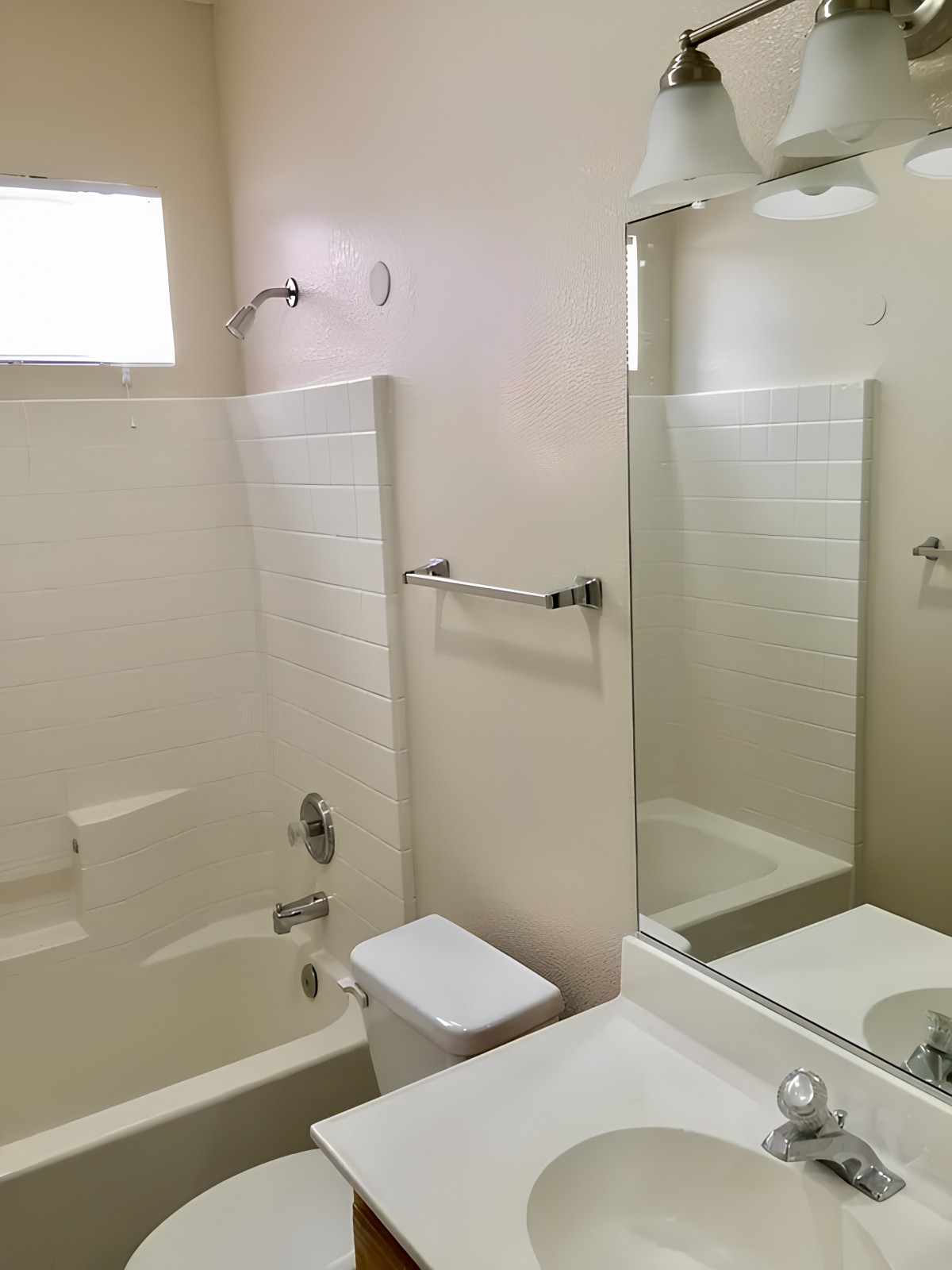A simple bathroom interior with a shower, sink, and toilet.