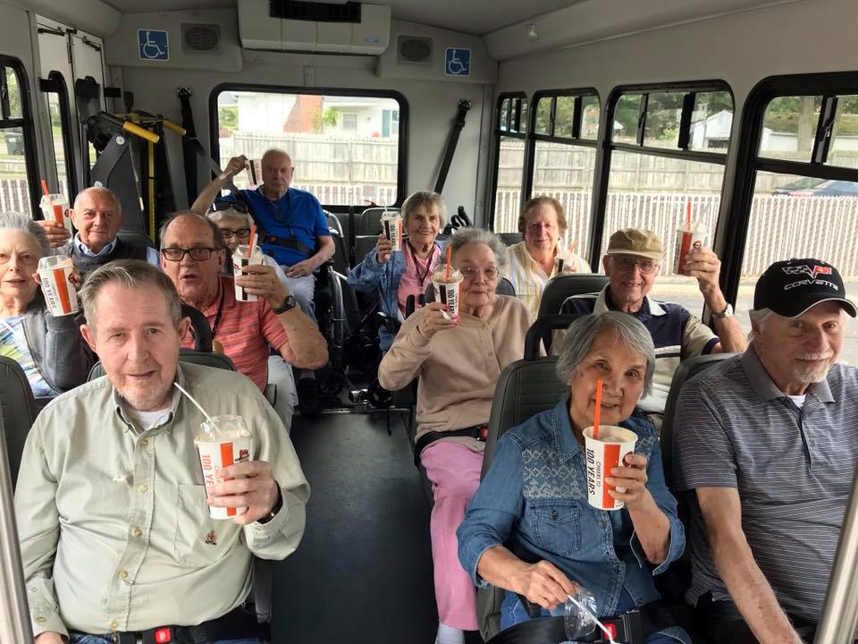 A cheerful group of people enjoying drinks on a bus.