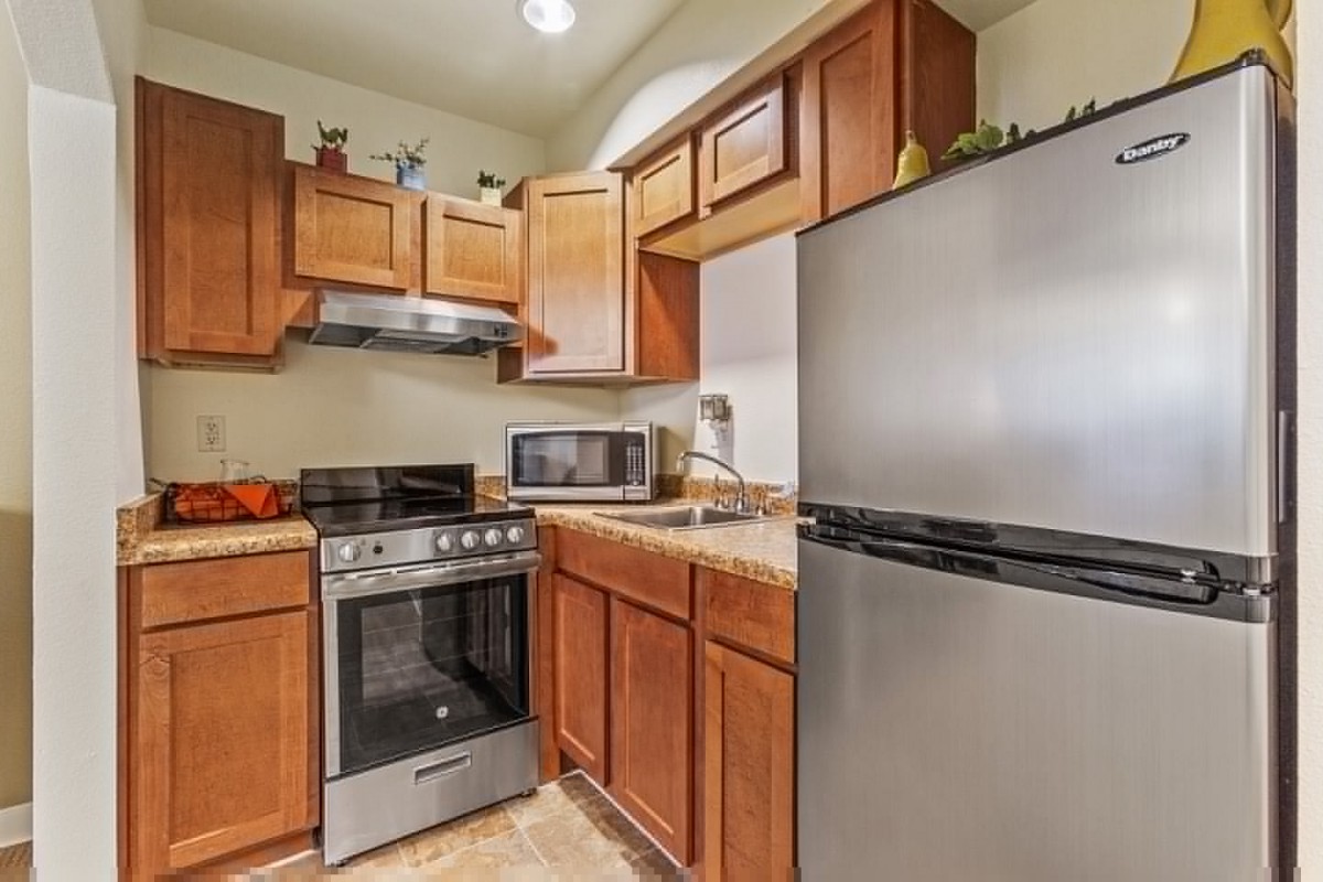 A modern kitchen with wooden cabinets and stainless steel appliances.