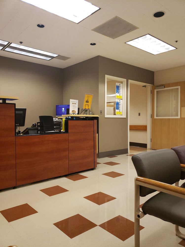 An empty office reception area with a desk and chairs.