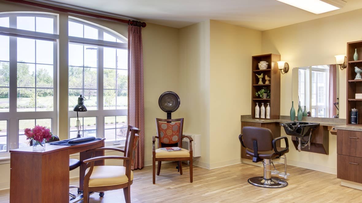 A cozy hair salon with stylish chairs and a large window.