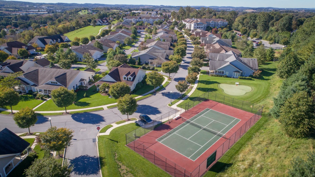 Aerial view of a suburban neighborhood with a tennis court.