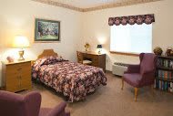 A cozy bedroom with a single bed, decorative elements, and comfortable seating.