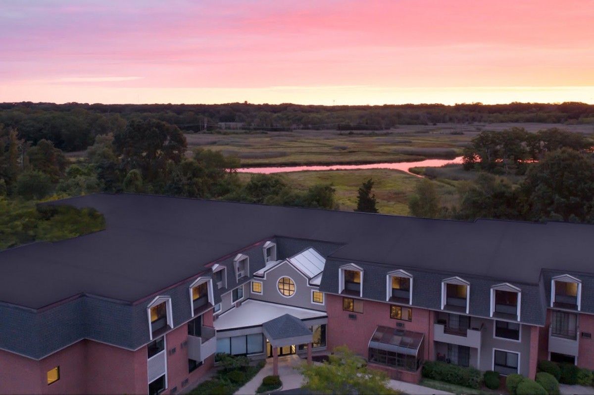 A beautiful hotel with a scenic sunset view over a river and lush landscape.