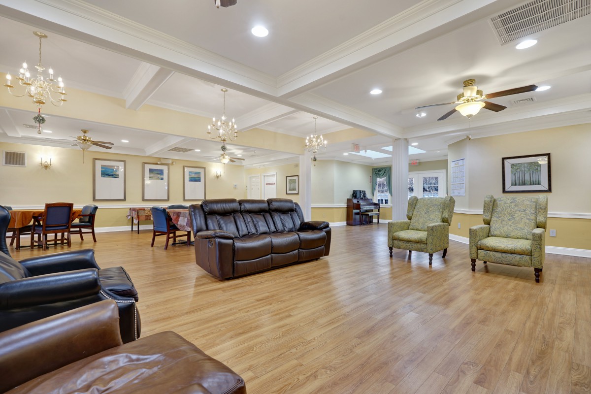 A spacious and well-lit living room with comfortable seating and wood flooring.