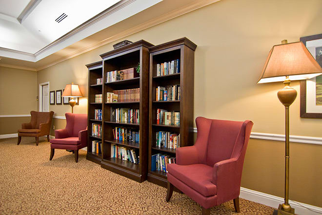 A cozy reading area with armchairs and a bookshelf filled with books.