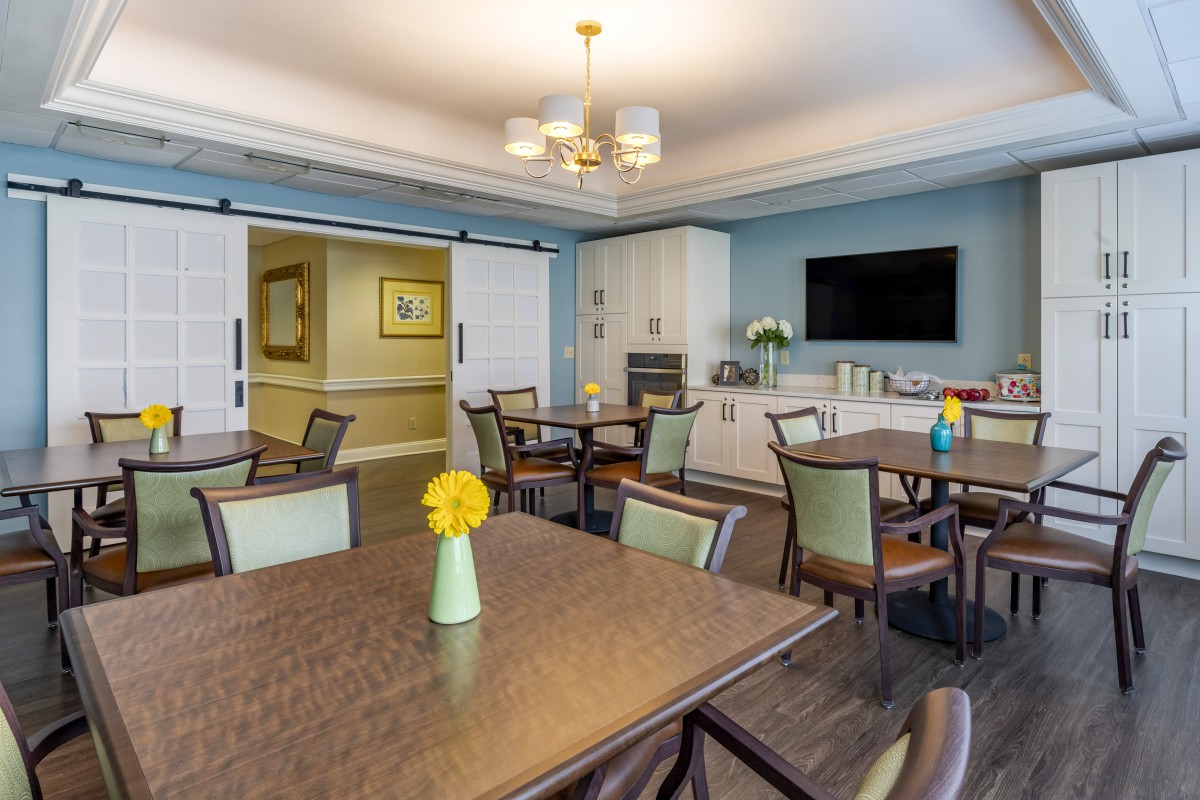 A modern dining area with tables and chairs, featuring elegant decor and bright lighting.