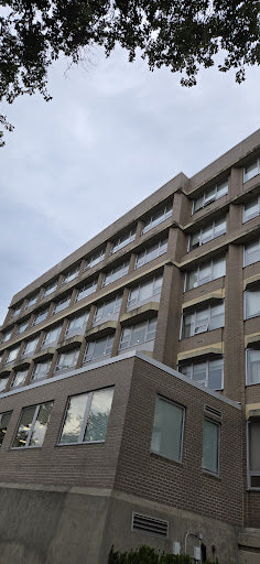 A modern building showcasing a combination of brick and glass architecture.