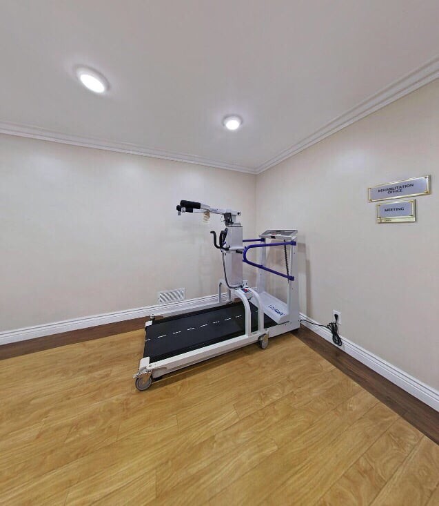 A fitness room featuring a treadmill and exercise equipment.