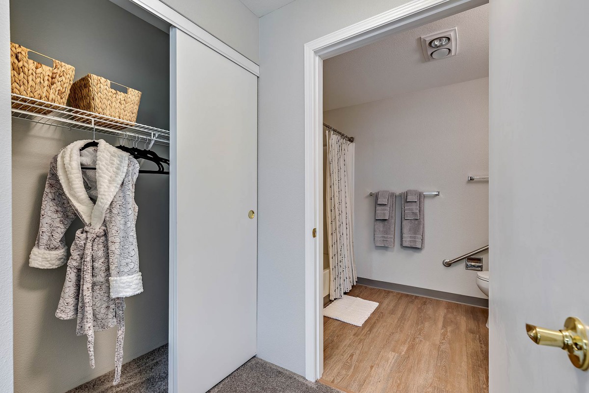 A view of a closet and bathroom area in a modern home.