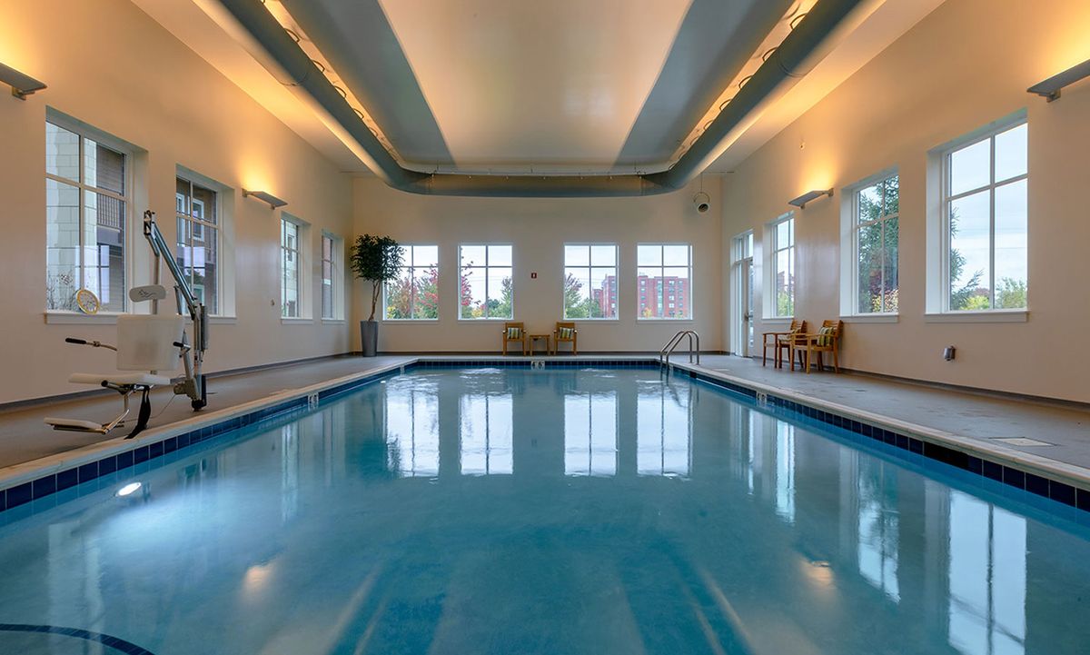 A luxurious indoor swimming pool with ambient lighting and comfortable seating.