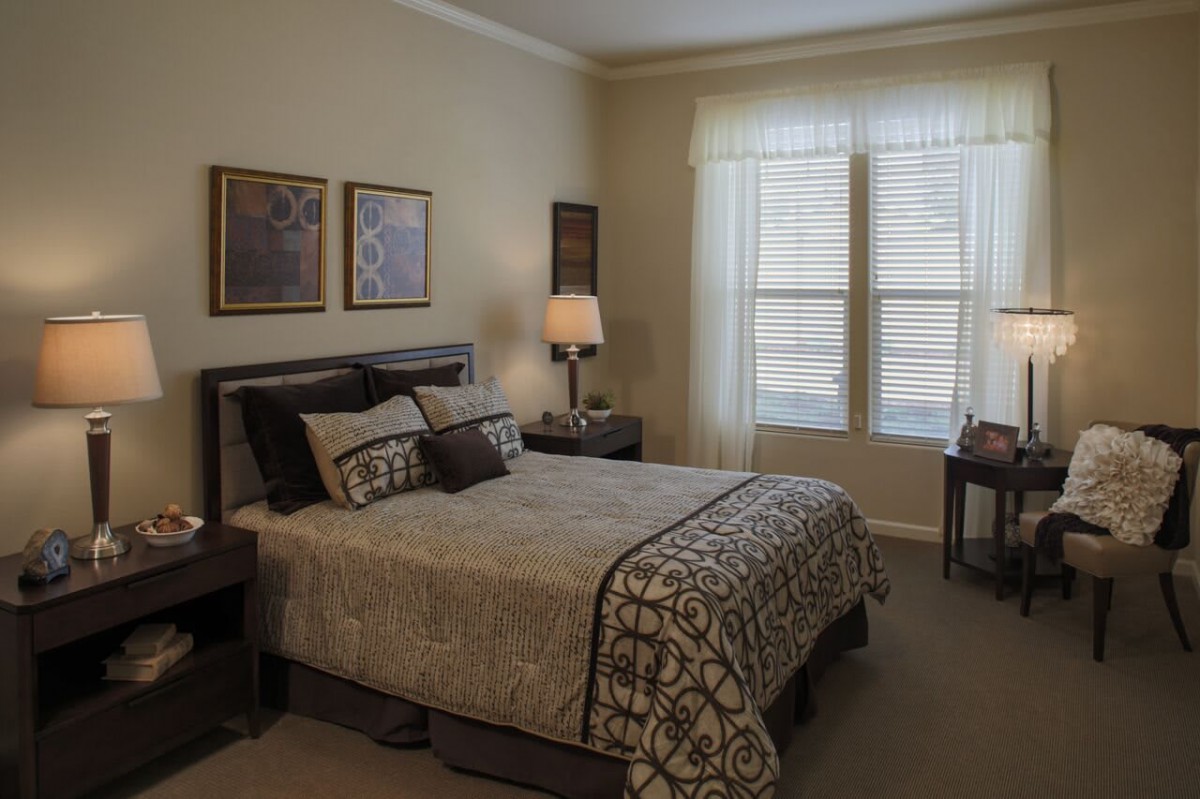 A cozy bedroom featuring a neatly made bed, soft lighting, and elegant decor.