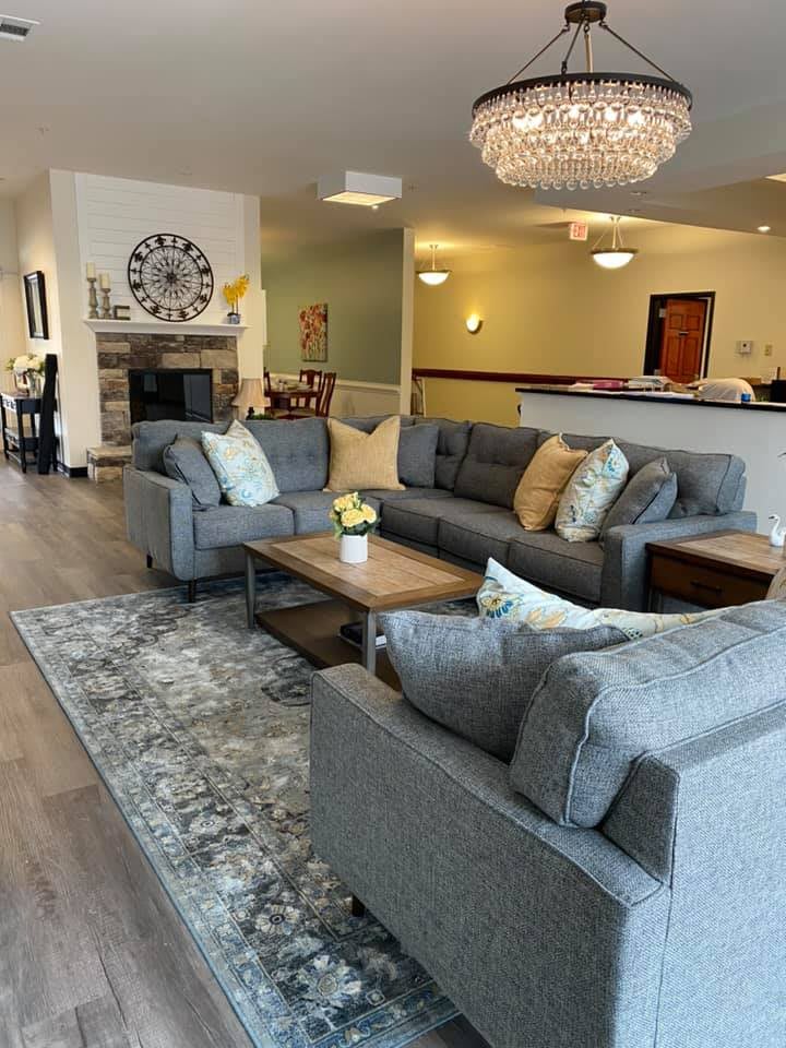 A cozy living room with modern furniture, featuring a chandelier and stylish decor.