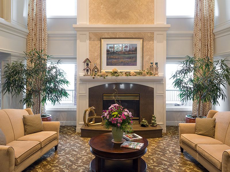 A cozy living room with a central fireplace, elegant decor, and comfortable seating.