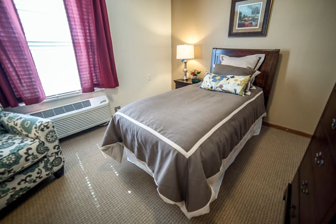 A small, cozy bedroom with a single bed and a lamp beside it.