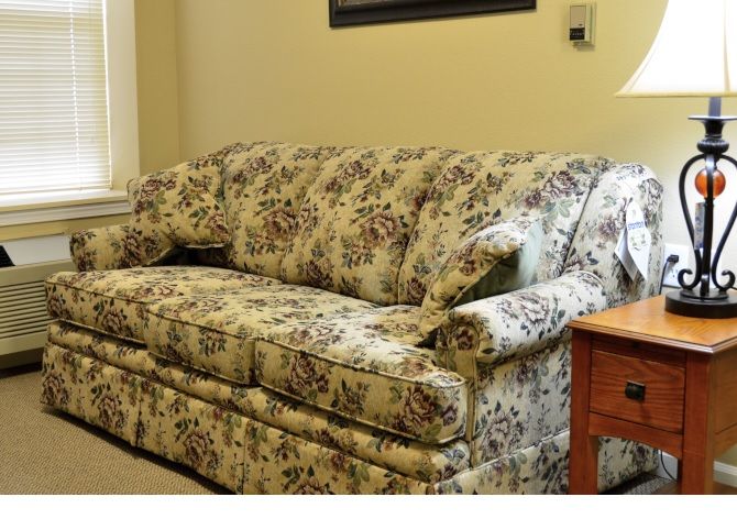 A floral patterned sofa in a cozy living room setting.