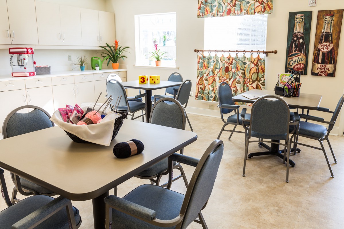 A bright and inviting dining area with neatly arranged tables and chairs, accented by colorful decor.