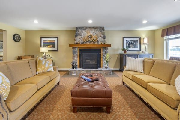 A cozy living room featuring a central fireplace and comfortable seating.