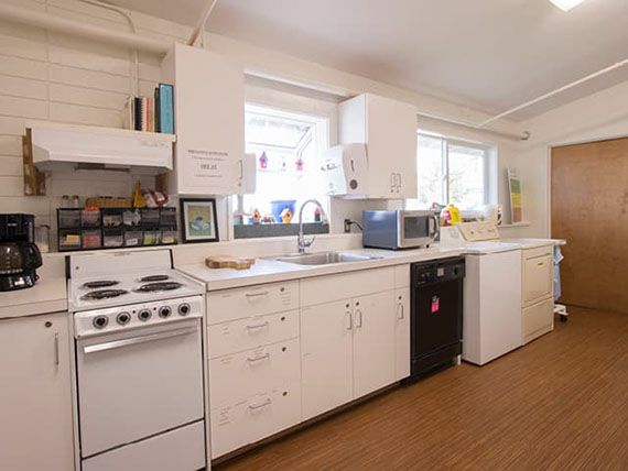 A modern kitchen with white cabinets and appliances.