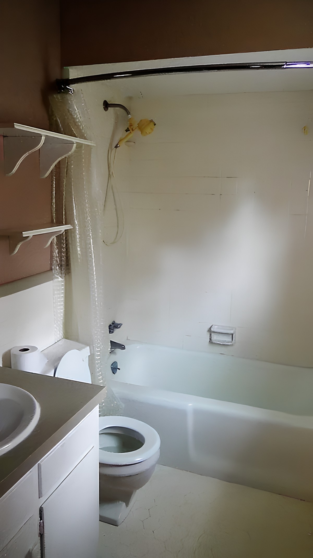 A bathroom with a bathtub, sink, toilet, shelves, and a mirror.