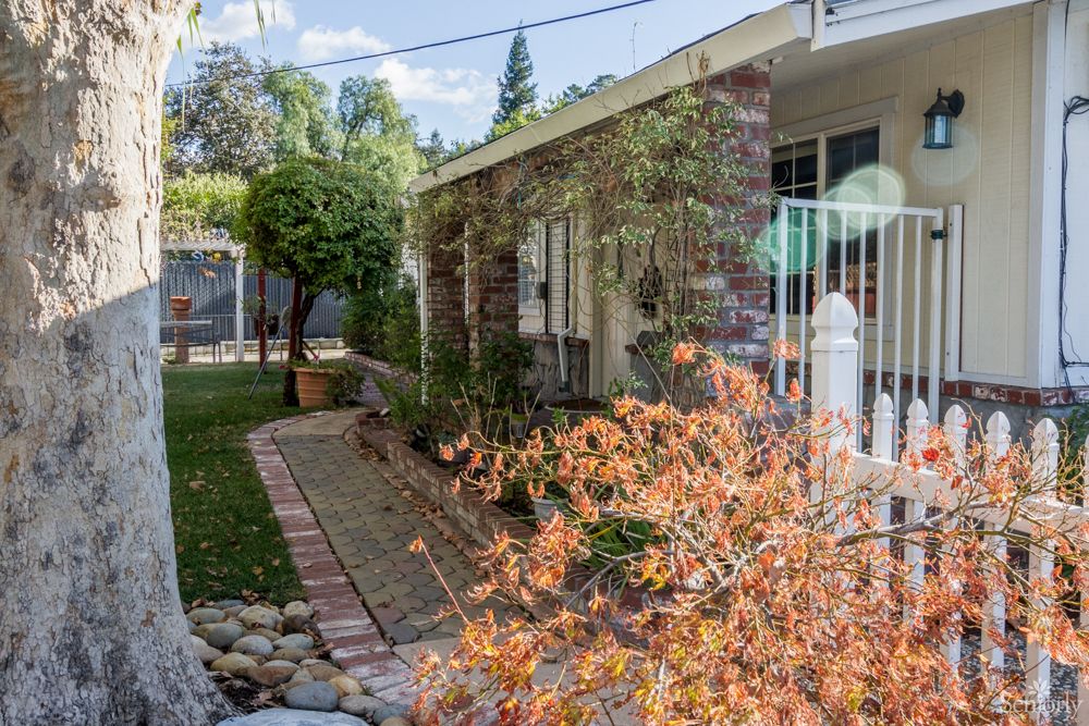 A charming house with a well-maintained garden and brick pathway.