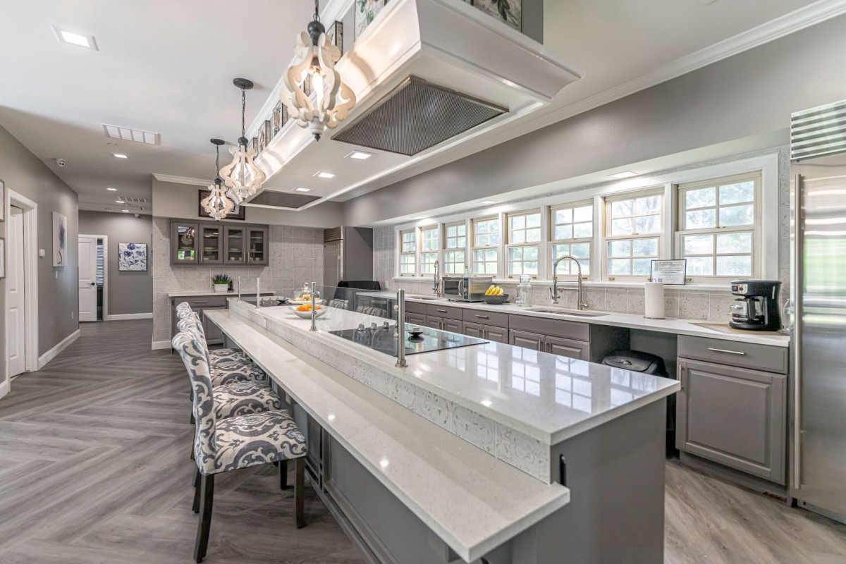 A modern kitchen with a large island and stylish pendant lighting.