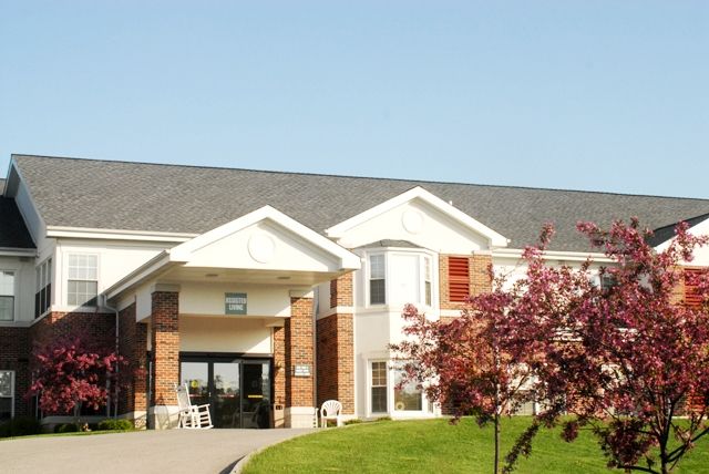 A suburban building with a main entrance and surrounding greenery.