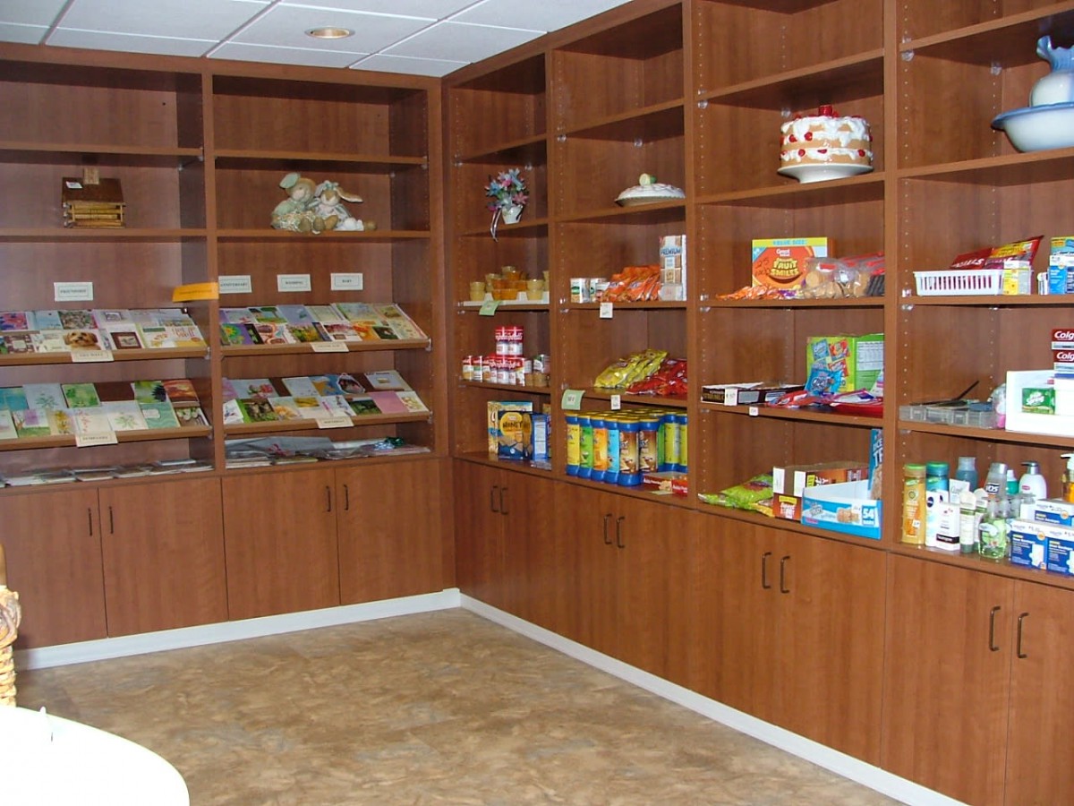 A small store with wooden shelves displaying various snacks and products.