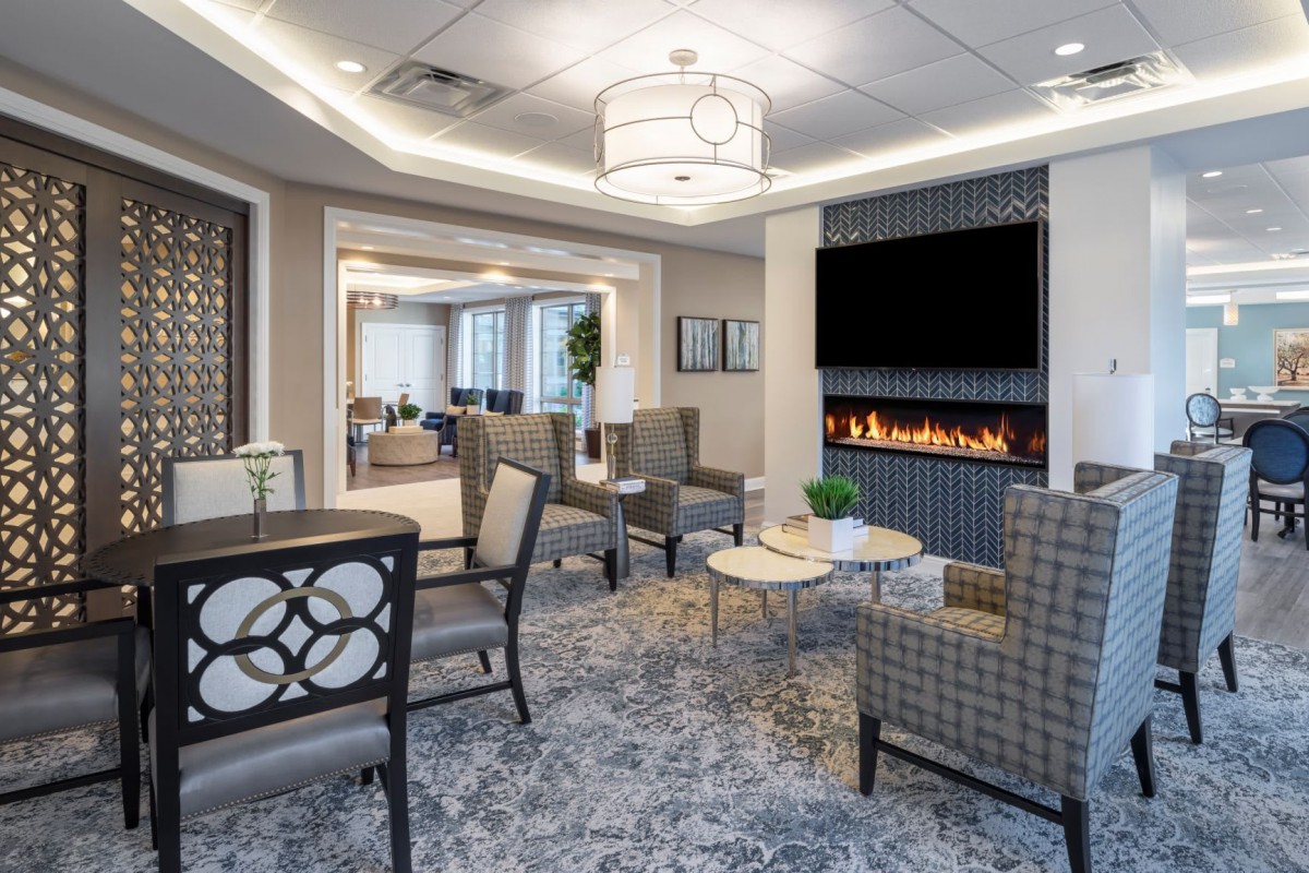 A modern lounge area featuring a cozy seating arrangement and a stylish fireplace.