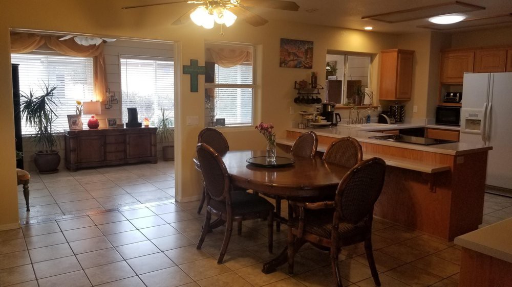 A cozy dining area with a wooden table and chairs, adjacent to a kitchen.