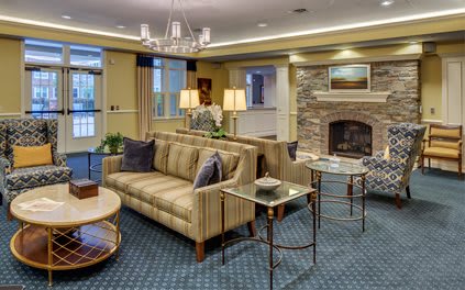 A cozy living room with elegant furniture and a stone fireplace.