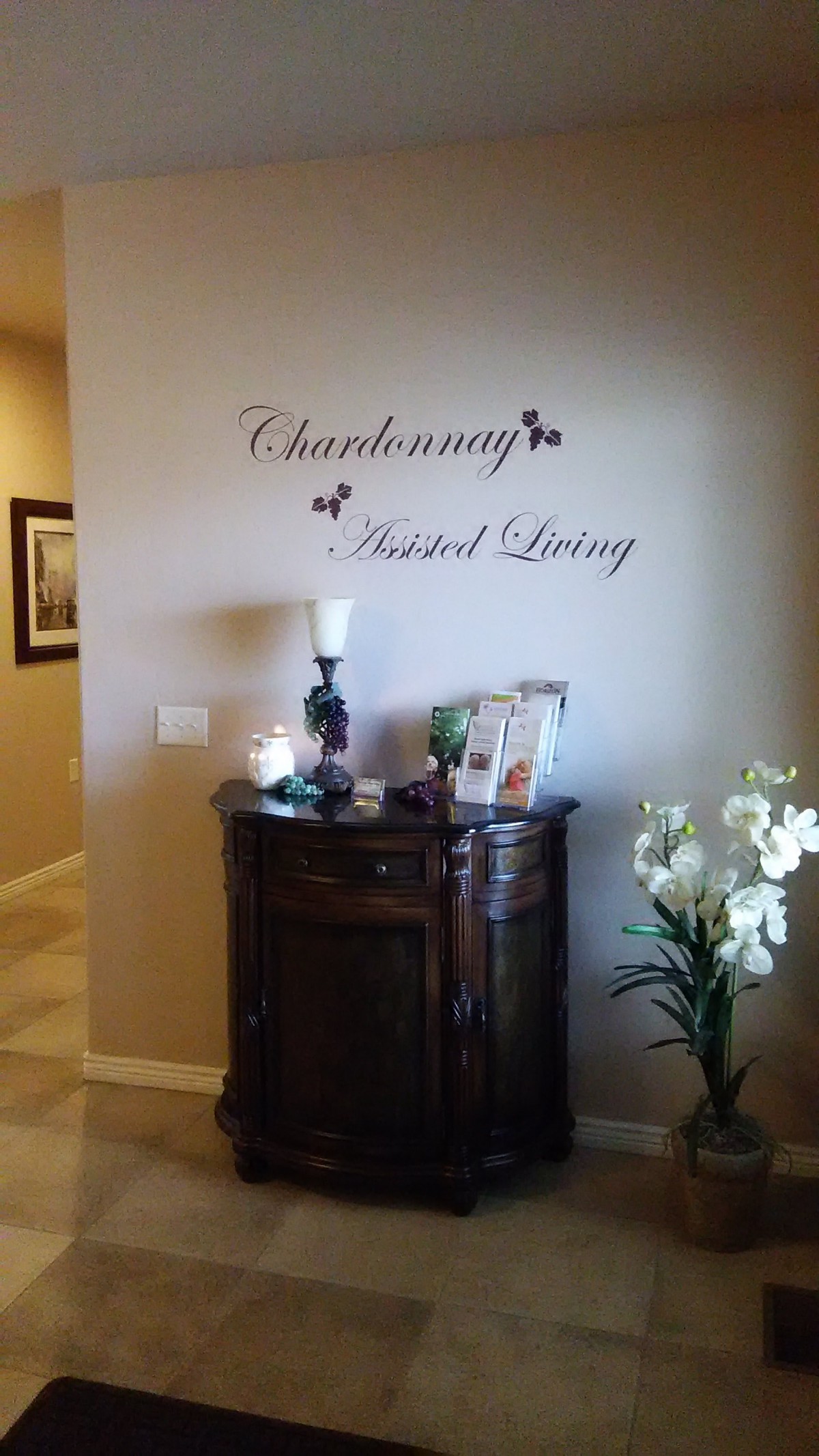 A warmly decorated foyer featuring a small wooden cabinet adorned with candles and flowers.