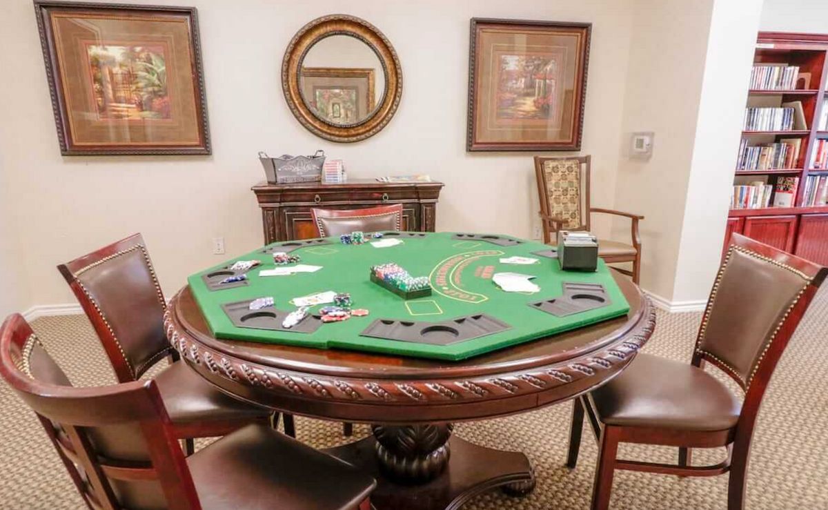 A poker table set up with cards and chips in a game room.
