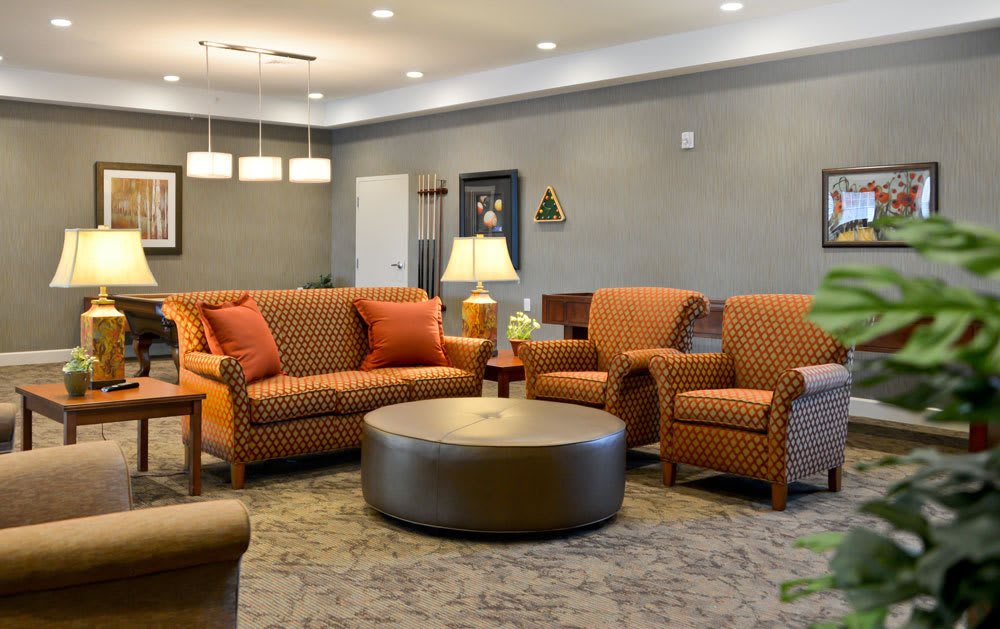 A cozy living room with orange furniture and a round coffee table.
