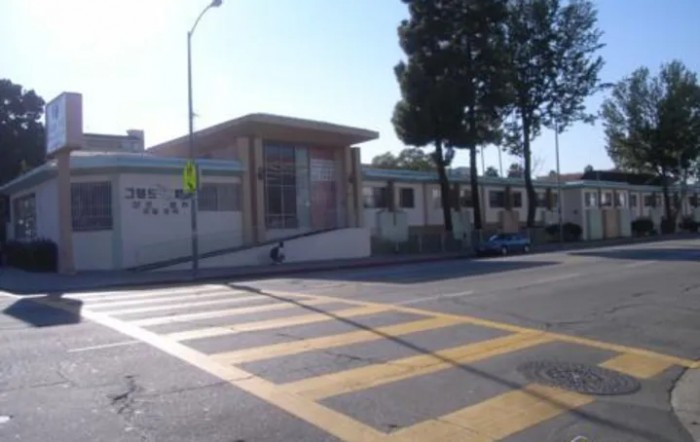 A view of a school building with a crosswalk in the foreground.