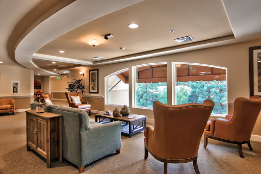 A cozy lounge area featuring comfortable seating and large windows that let in natural light.