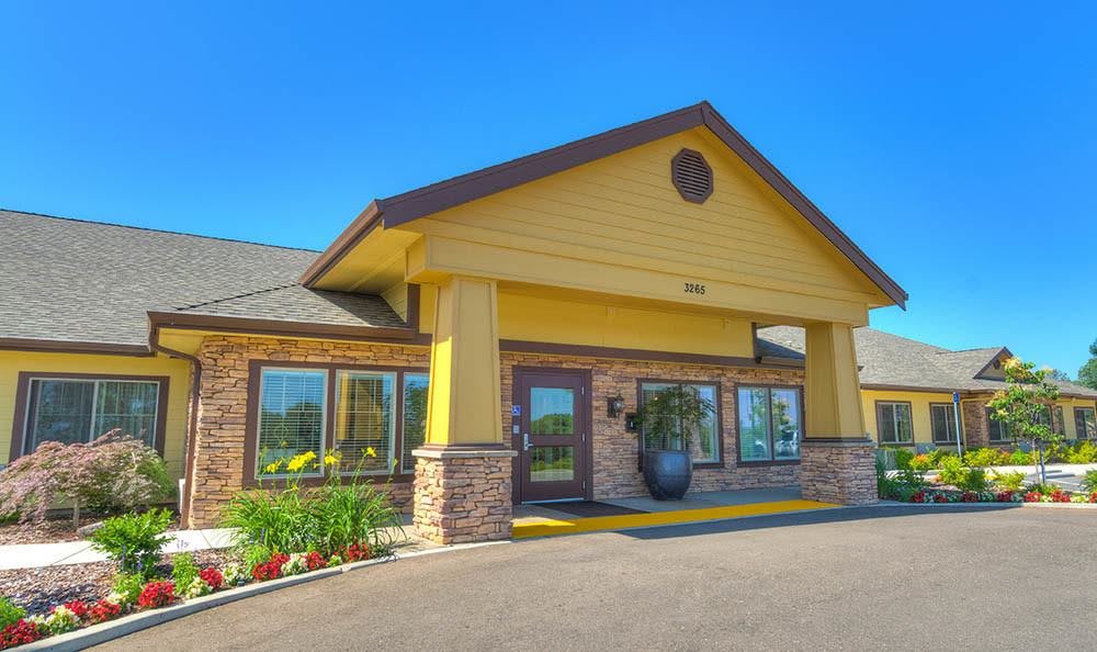 A hotel building with a yellow facade and large entrance, set against a clear blue sky.